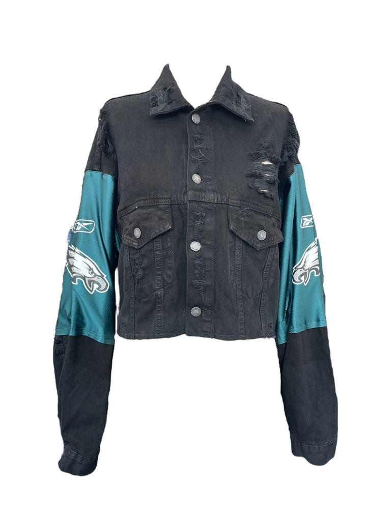 Black denim jacket with teal sleeves featuring sports team logos on a white background