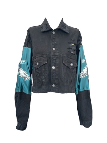 Black denim jacket with teal sleeves featuring sports team logos on a white background